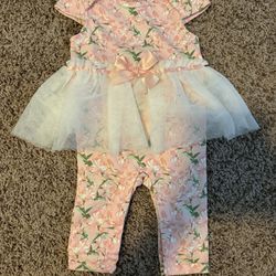 Pink floral infant outfit with attached tulle skirt and bow.