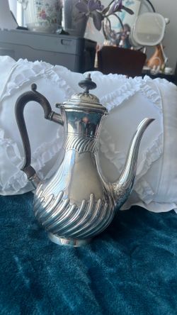 An antique English silver-plated coffee pot with fluted decoration.