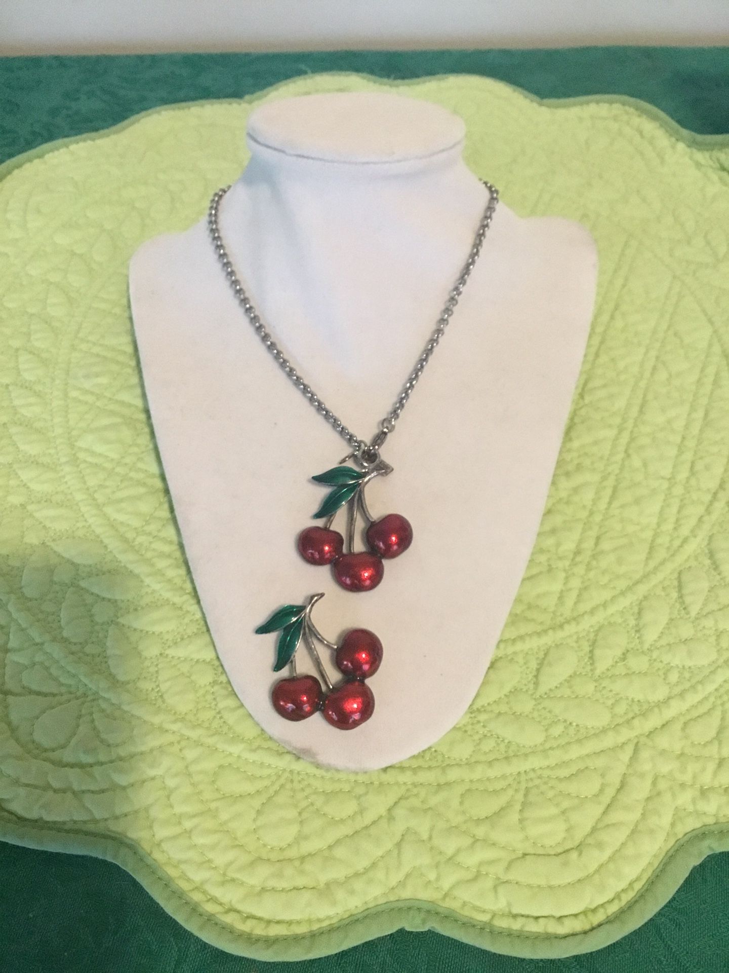 Two charming vintage enamel metal red cherry pieces one is a necklace and one is a Charm they are both signed JJ