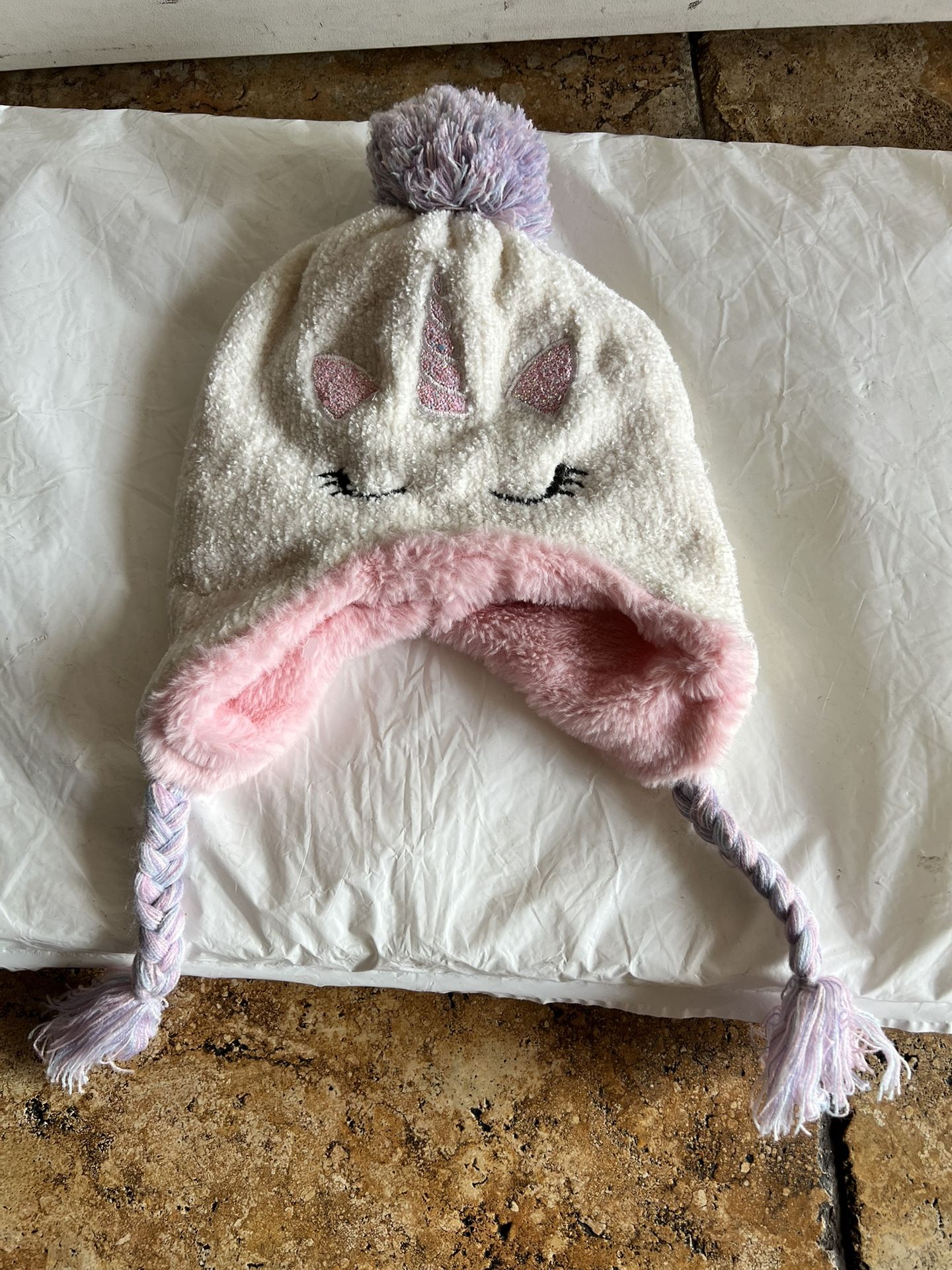 Adorable soft unicorn knit hat with pink lining and braided tassels. Features unicorn design with ears and horn.  New no tags  See Pictures Size M/L