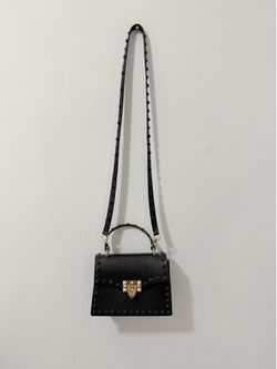 black jelly crossbody handbag with gold accents and studded details