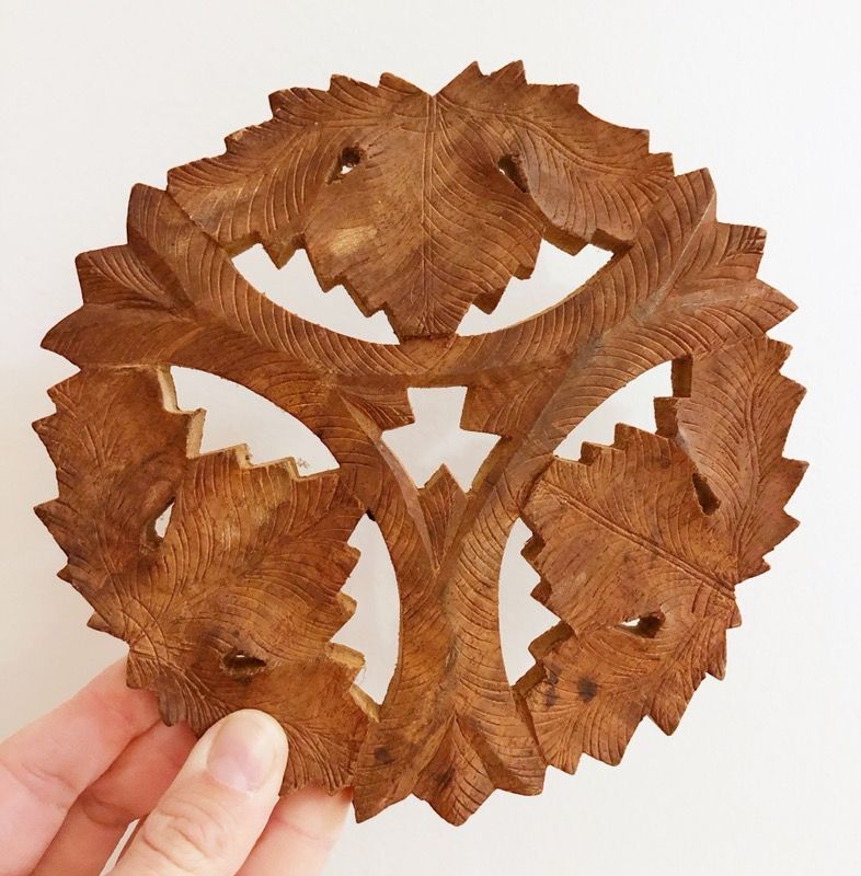 Carved wood trivet with gorgeous detail. 6” wide.