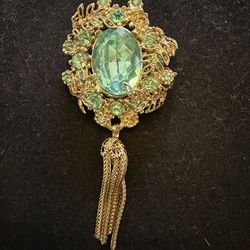 vintage Florenza gold-tone brooch featuring a large oval aqua green rhinestone