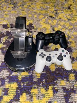 Two PlayStation 3 controllers with charging stand.