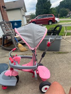 This image shows a pink and gray Radio Flyer 4-in-1 Activity Stroll 'N Trike