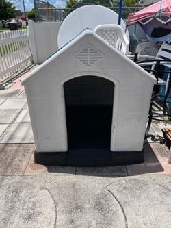 Sturdy plastic dog house in good condition, including a food bowl. Dimensions: 36 1/2 inches long, 34 inches wide; height to the peak is 39 inches, an