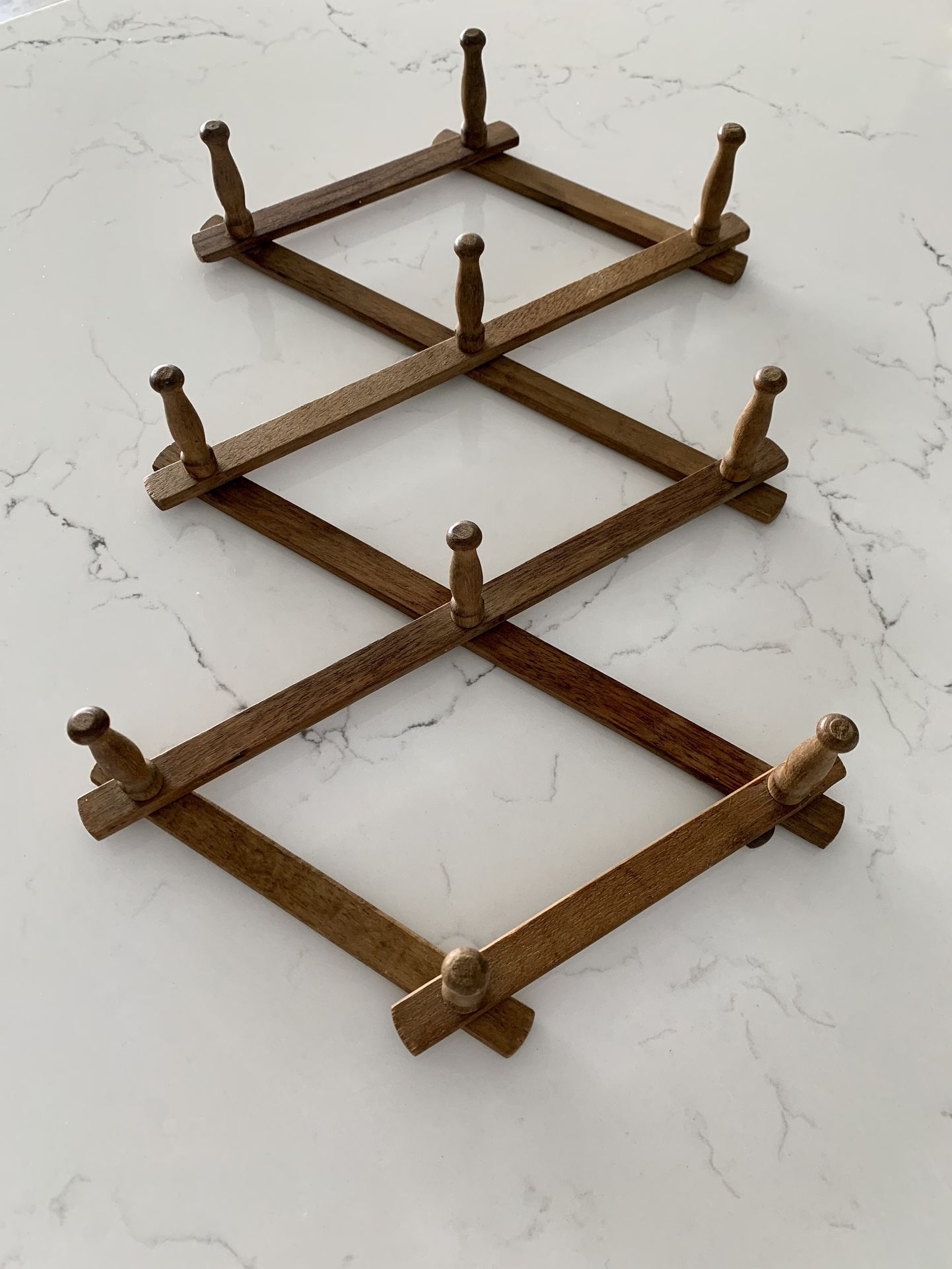 Vintage wood accordion mug rack / hat rack. 10 hooks. 13” tall. Three metal hooks on back to hang. Original foil sticker on back marked Nevco
