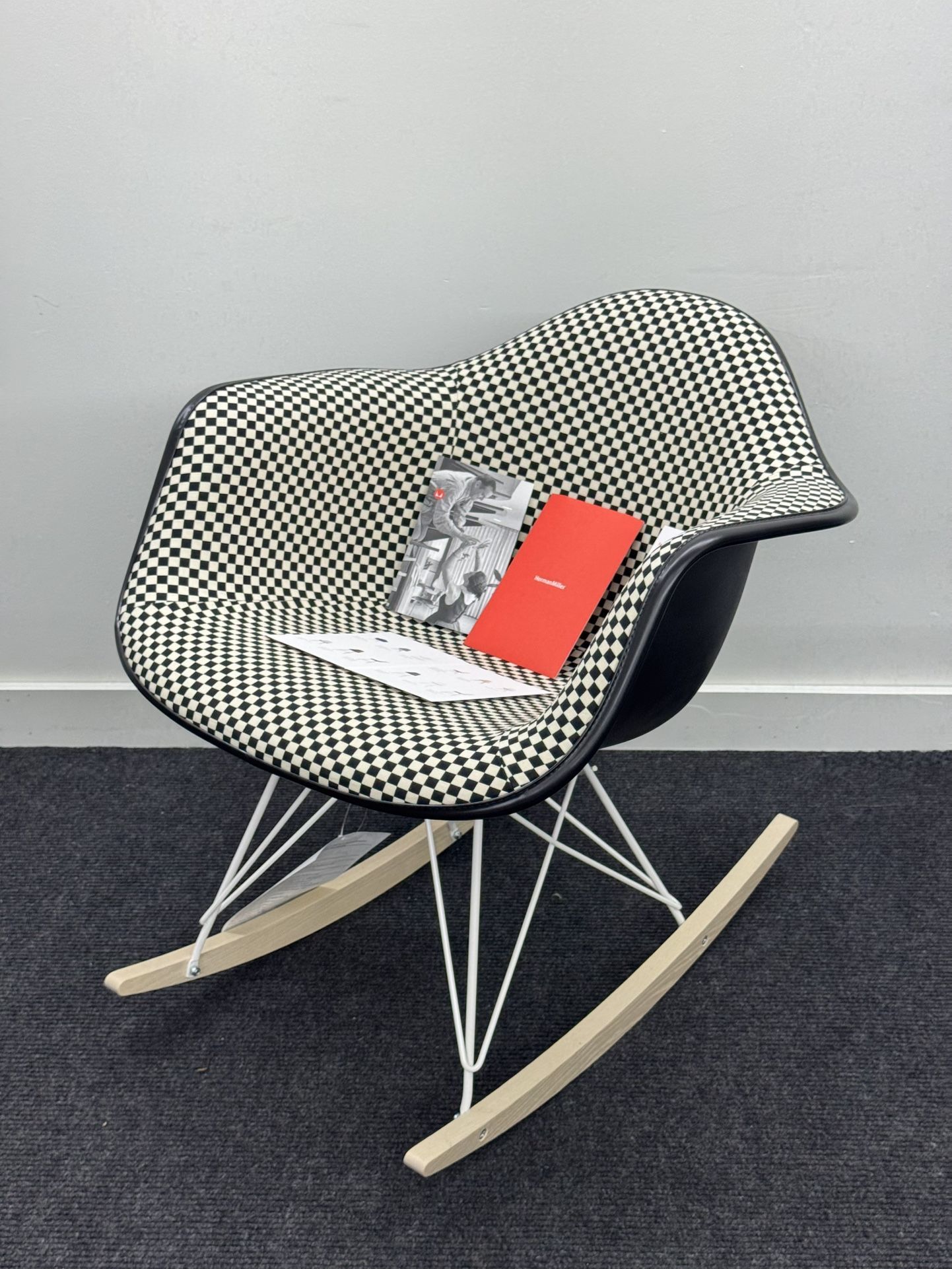 BRAND NEW HERMAN MILLER EAMES UPHOLSTERED MOLDED PLASTIC ARMCHAIR, ROCKER BASE. BLACK/WHITE CHECKERED PATTERN
