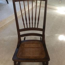 Antique oak rocking chair with cane seat. Circa 1900.