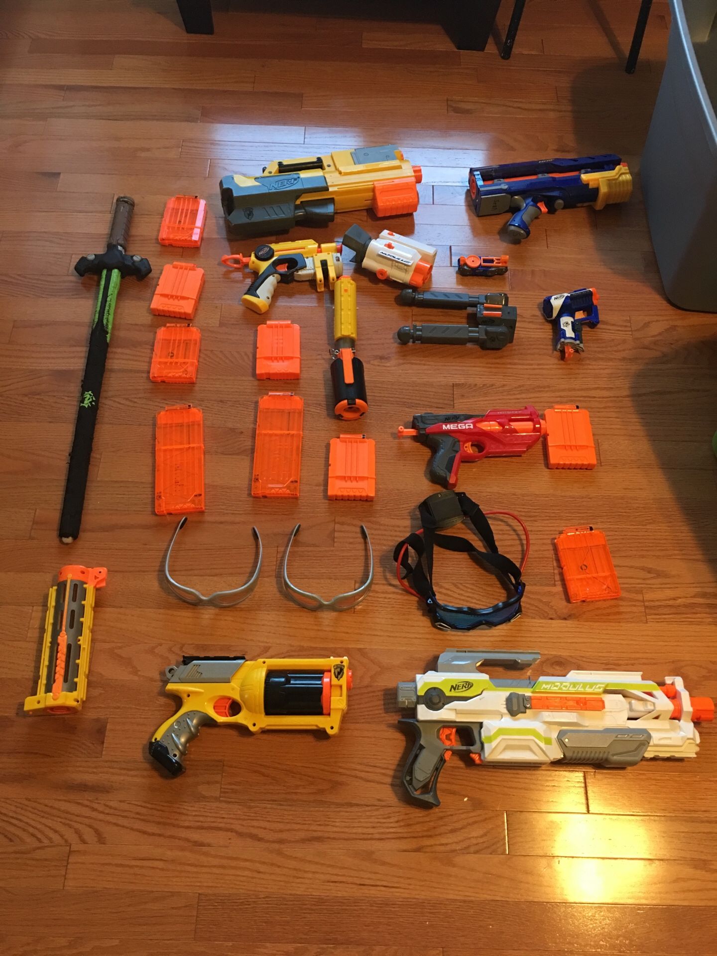 Variety of nerf guns, mags, and goggles with nerf sword