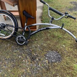 Trail a bike. To put behind your bike for a child that doesn’t know how to ride a bike.