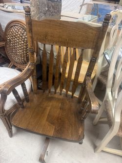 traditional wooden rocking chair with a spindle back and scrolled seat