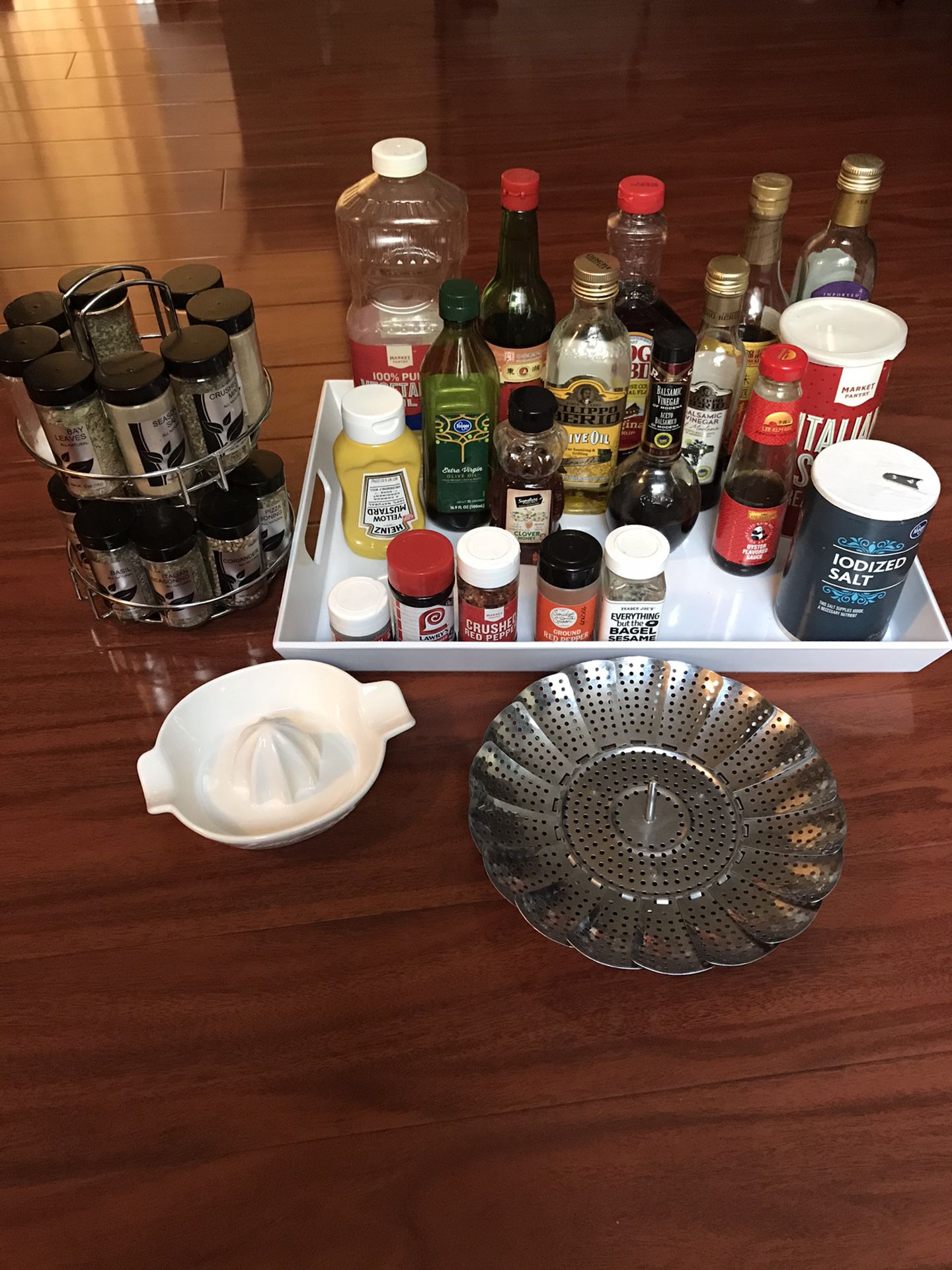Kitchen goods: spice rack, veggie steamer, lemonade, white container with condiments