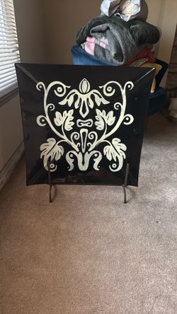 Square-format decorative plate in black and beige.