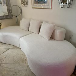 Modern curved modular sofa in a soft cream/ivory bouclé fabric