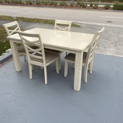 Beige wooden table with four chairs