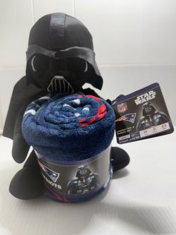 Official NFL licensed Star Wars Darth Vader plush paired with a rolled Patriots throw. Soft plush features Darth Vader design and team logo accents. B