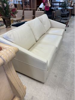 Modern, three-cushion cream leather sofa features sloped track arms, a sleek off-the-floor profile - excellent condition - 77” x 37” - Retail: $2300