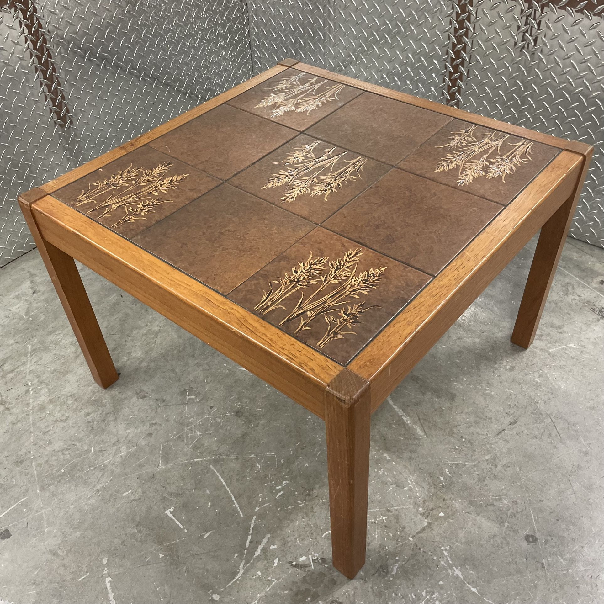 Square Danish teak tile coffee table with wheat theme located by the Miami Design District and measures 27” l x 27” w x 19” h.