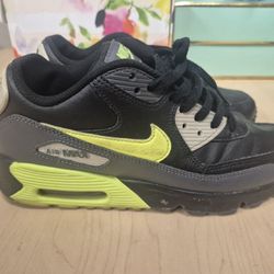 Nike Air Max 90 sneakers in a black, dark grey, and volt green colorway. 