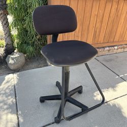 Comfortable swivel stool on rollers with foot rest