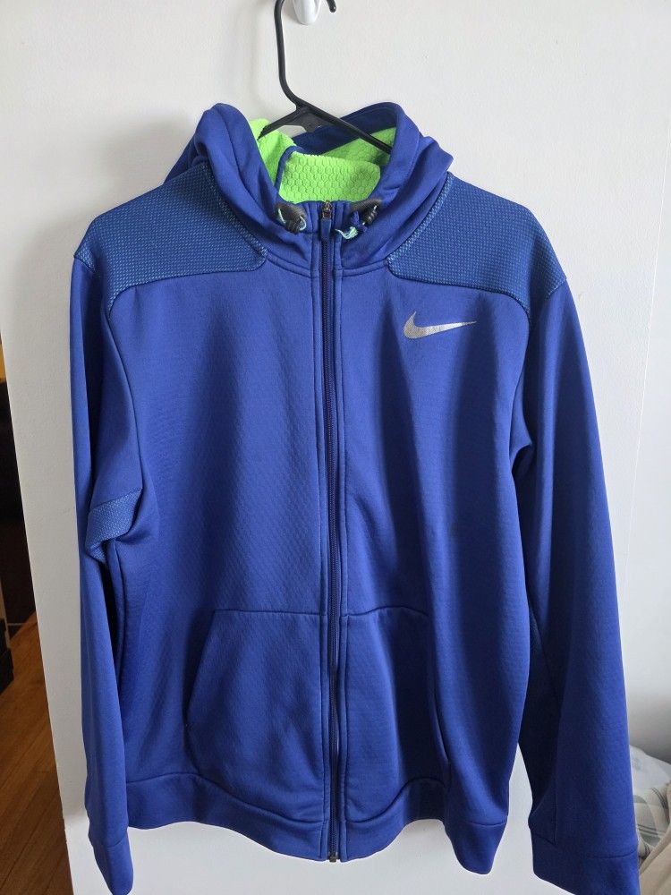 Nike Therma-FIT full-zip hoodie in blue with a lime green inner lining.
