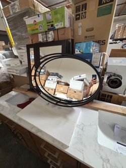 Unique oval mirror has black frame with cool geometric design. Great for any room.