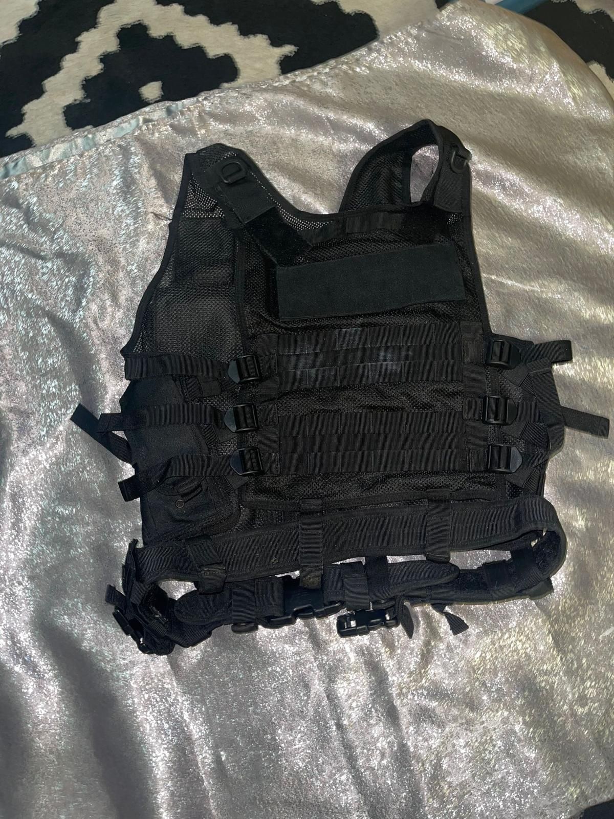 black tactical vest. It is designed for tactical and outdoor use, often seen in activities like airsoft, paintball, hunting, or training. These vests