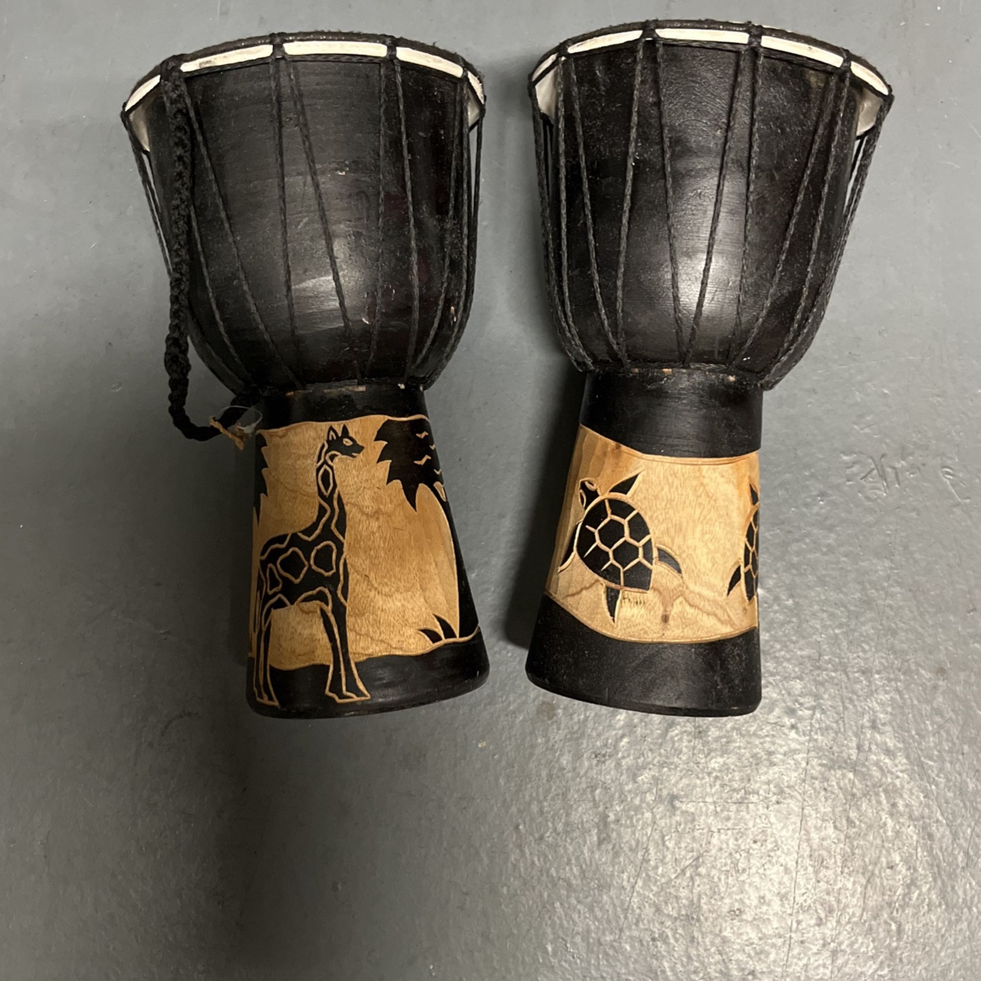 Two Black Carvd Miniature African Bongos Thick wood that has been carved skins, are still good heated rope to hold