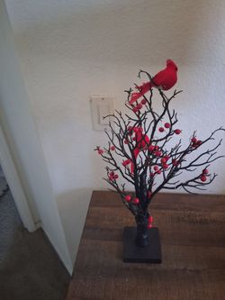 This black branch tabletop decoration features dark wrapped stems, bright red berry clusters, and a vibrant red cardinal accent