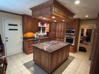Complete kitchen cabinet set with granite countertop and island.