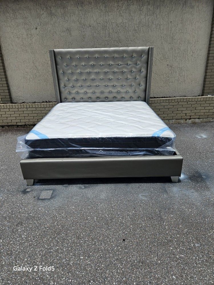 Silver King Size Sofia Vergara Upholstery Bed Frame With Brand New King Size Plush Pillow Top DreamCloud Premier Hybrid Mattress and Box In Plastics
