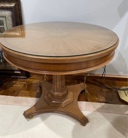 Vintage solid wood round pedestal table with glass top and gold wheels- 22” tall x 28” round