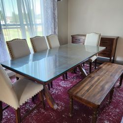 Dining table with glass top and chairs and bench
