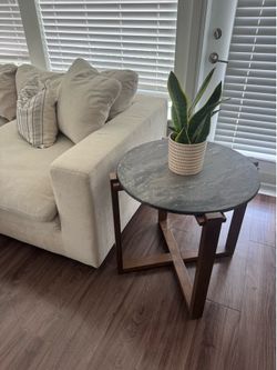 Modern side table with marble top and wooden base.