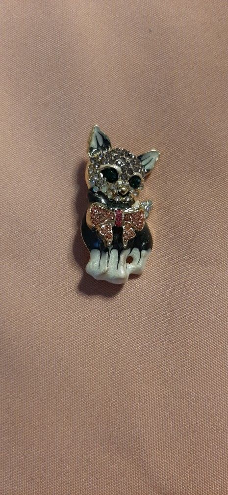 Silver kitten brooch with rhinestones and a bow tie.