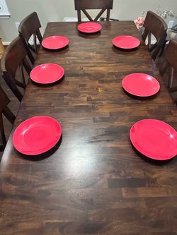 Stack of red ceramic plates. Seven in total.
