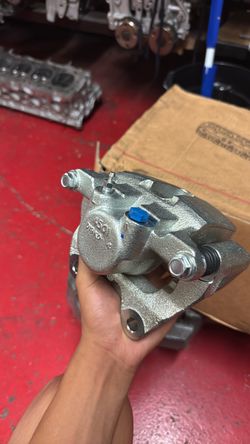 rear left brake caliper for a Dodge Charger Enforcer Pursuit (model years 2014-2020), complete with its mounting bracket