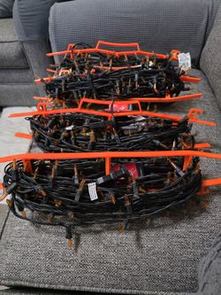 Sets of orange holiday string lights with orange holders