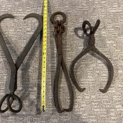 2 old ice tongs and a tong for hay bales