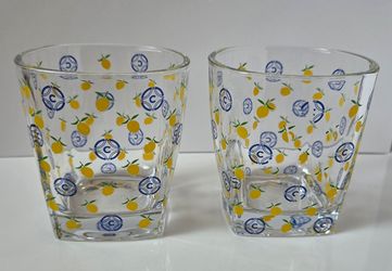 Set of two lowball / rocks glasses featuring a yellow lemon print and the blue Cîroc vodka logo