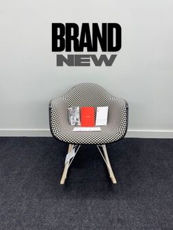 BRAND NEW HERMAN MILLER EAMES UPHOLSTERED MOLDED PLASTIC ARMCHAIR, ROCKER BASE. BLACK/WHITE CHECKERED PATTERN