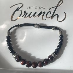 A red tiger’s eye, onyx, and silver beaded bolo bracelet. 