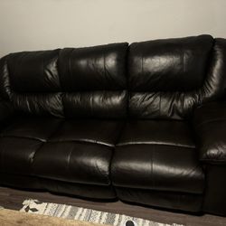Three seat reclining, faux, leather sofa. Dark brown. Middle seat back folds down for tray/cupholders.