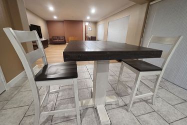 Bar height Dining Table + 2 Chairs Stunning two-tone bar-height dining table with 2 matching chairs. Dark espresso wood top with white pedestal base —