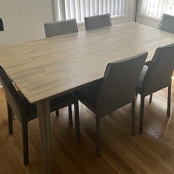 Beautiful solid wood dining table set with 6 metal chairs covered in leather from living spaces. In Excellent condition! 