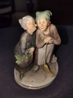 Old ladies share a secret; statue