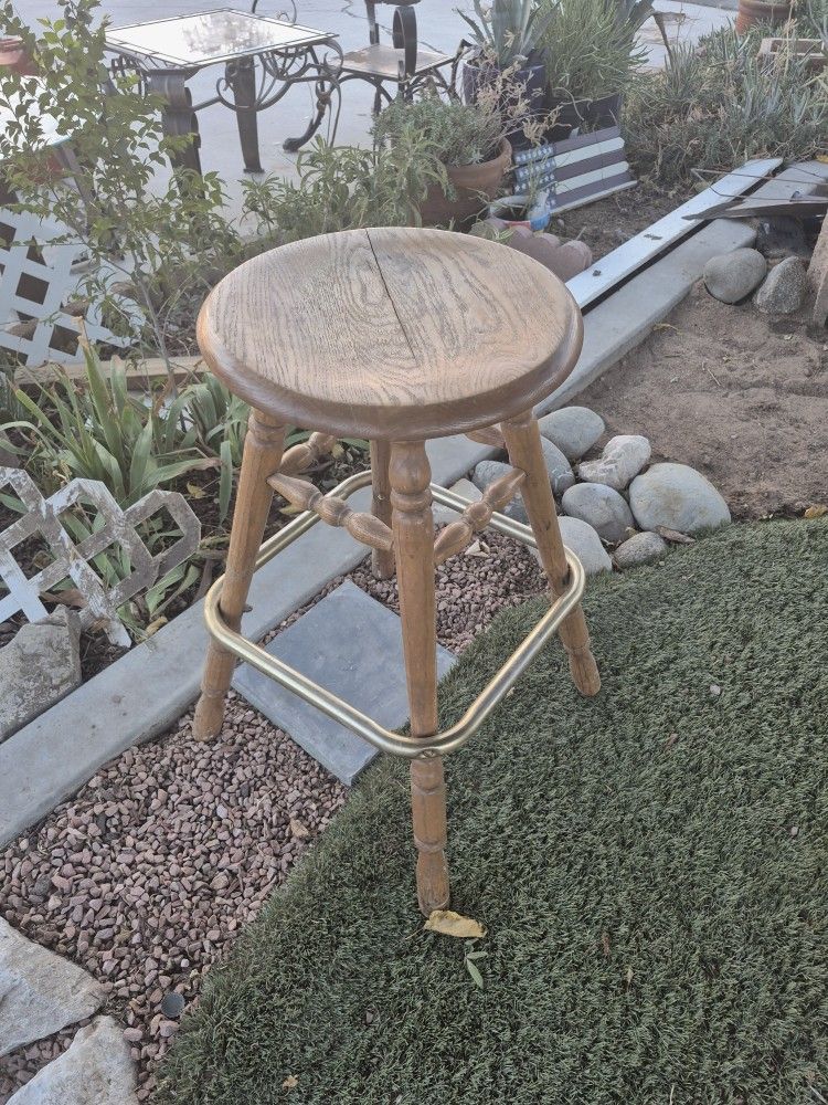 wooden bar stool with a brass footrest
