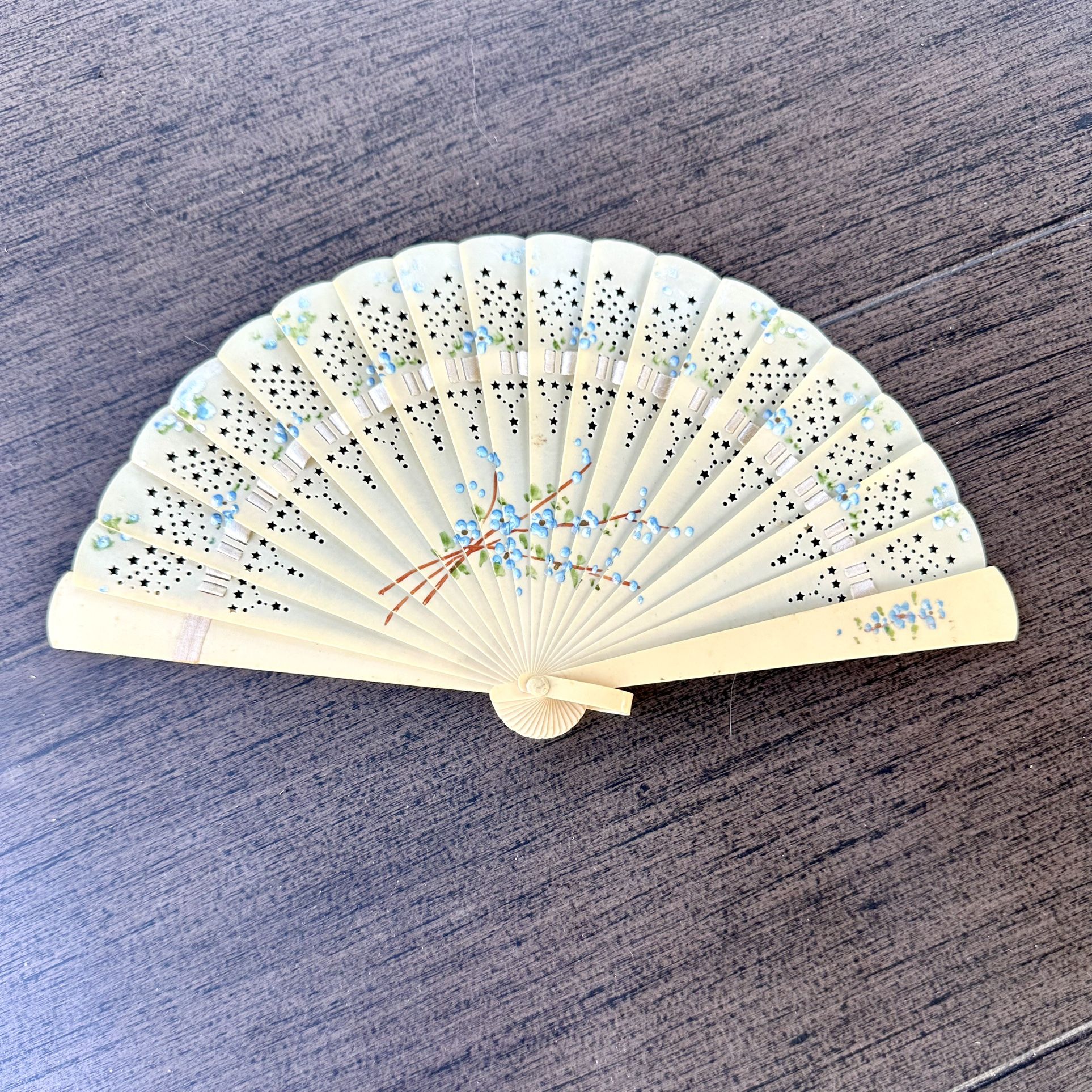 Antique vintage hand-folding celluloid fan with blue flowers