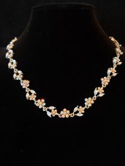 $10. Classic flowery gold tone rhinestone choker necklace. Rhinestones are white and yellow. 17 in. long. 1/4 inch wide.